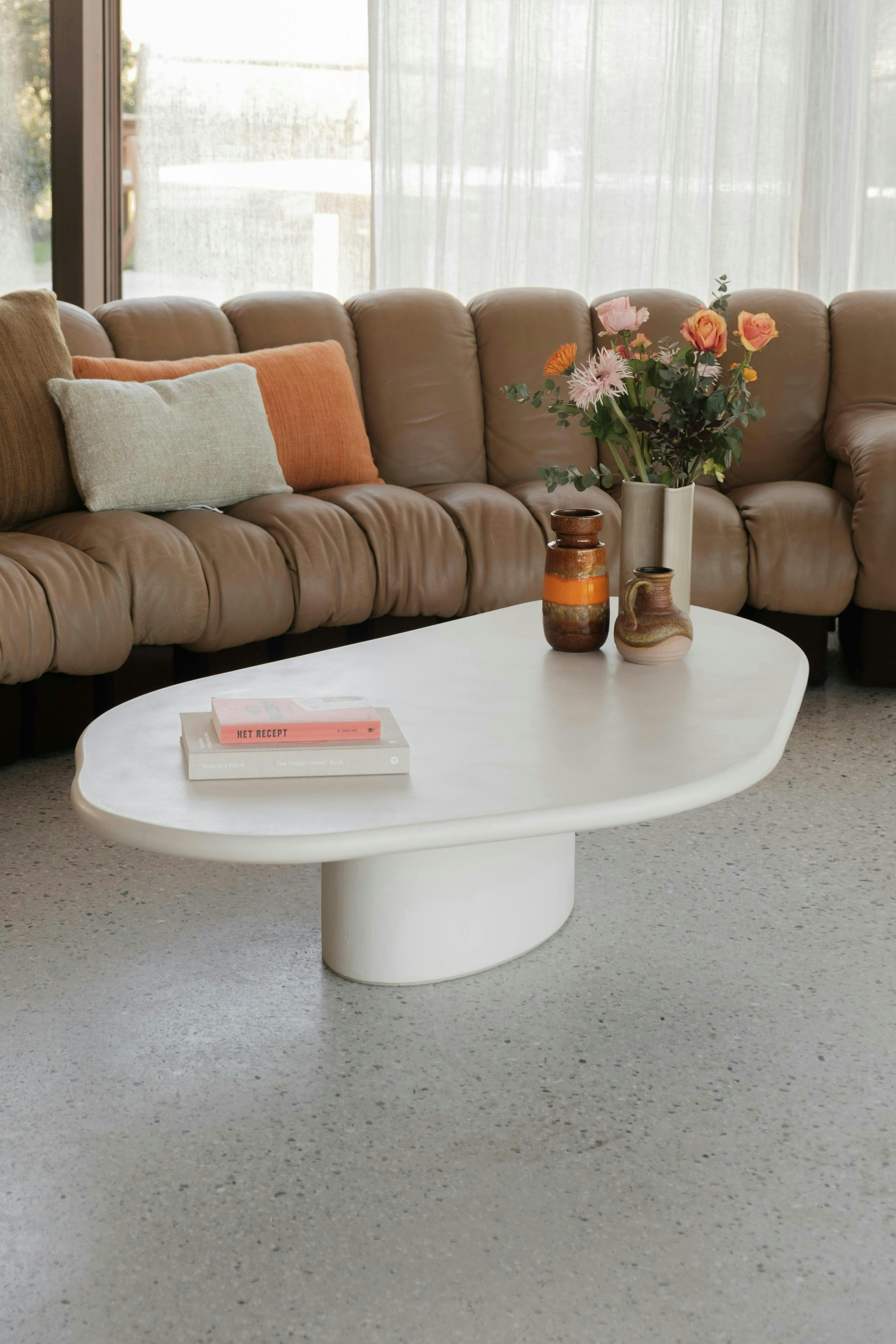 coffee table furniture table tabletop living room room couch flower flower arrangement plant